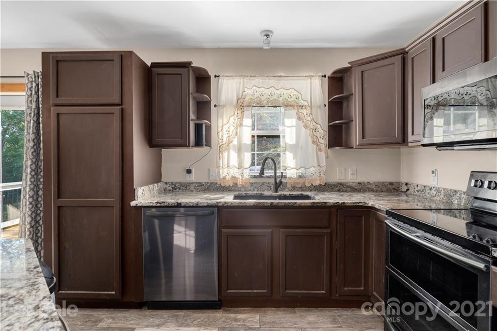 301 Fowler Lane Clyde, NC 28721 - Photo 6 of 47 a kitchen with stainless steel appliances granite countertop a stove a refrigerator and a sink