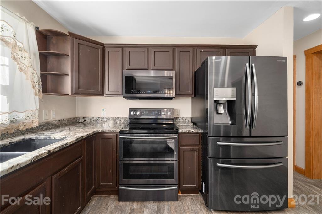 301 Fowler Lane Clyde, NC 28721 - Photo 7 of 47 a kitchen with a refrigerator stove and microwave