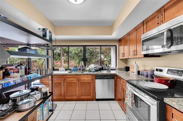 a kitchen with stainless steel appliances a stove sink microwave and cabinets