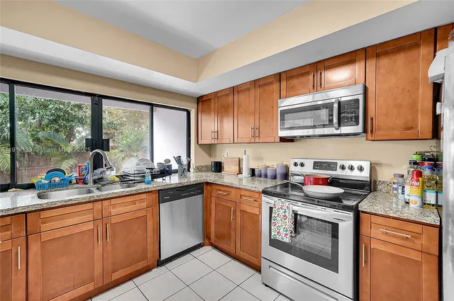 a kitchen with sink a large window and a wooden floor