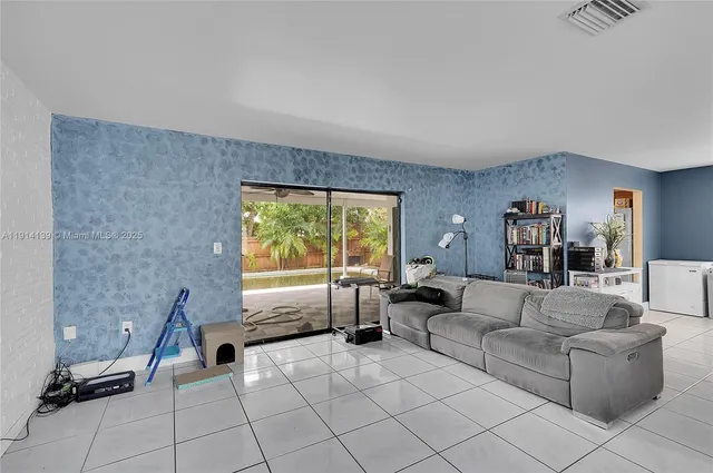a living room with furniture and a floor to ceiling window