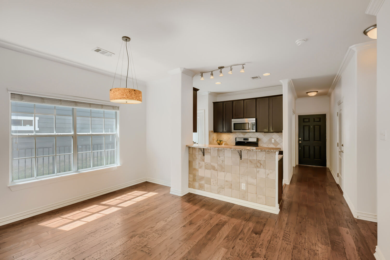 6715 Windrift Way, Unit 28 Austin, TX 78745 - Photo 10 of 19 Rich hardwood floors flow through this dining area, leading to an inviting kitchen and entry.