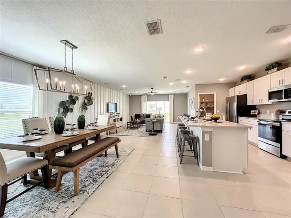 a dining room with wooden floor a chandelier a wooden table and chairs