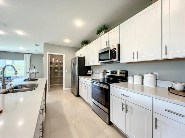 a kitchen with a sink stainless steel appliances and white cabinets