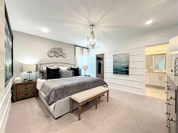 a spacious bedroom with a bed and a flat screen tv
