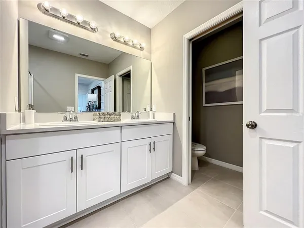 a bathroom with a double vanity sink mirror and shower