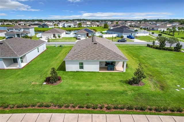 an aerial view of a city with lots of residential buildings ocean and mountain view in back