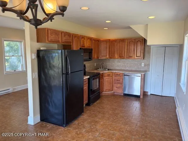 a kitchen with stainless steel appliances granite countertop a refrigerator a sink a stove and a microwave oven with wooden floor