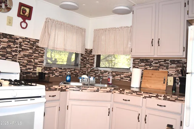a kitchen with appliances a sink and a stove top oven
