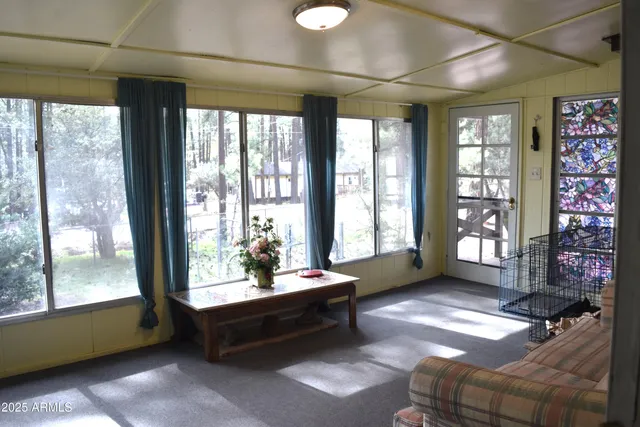 a living room with furniture and a floor to ceiling window