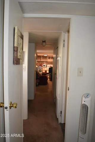 a view of a hallway with closet and a living room