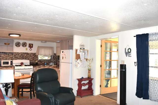 a dining room with furniture and a kitchen view