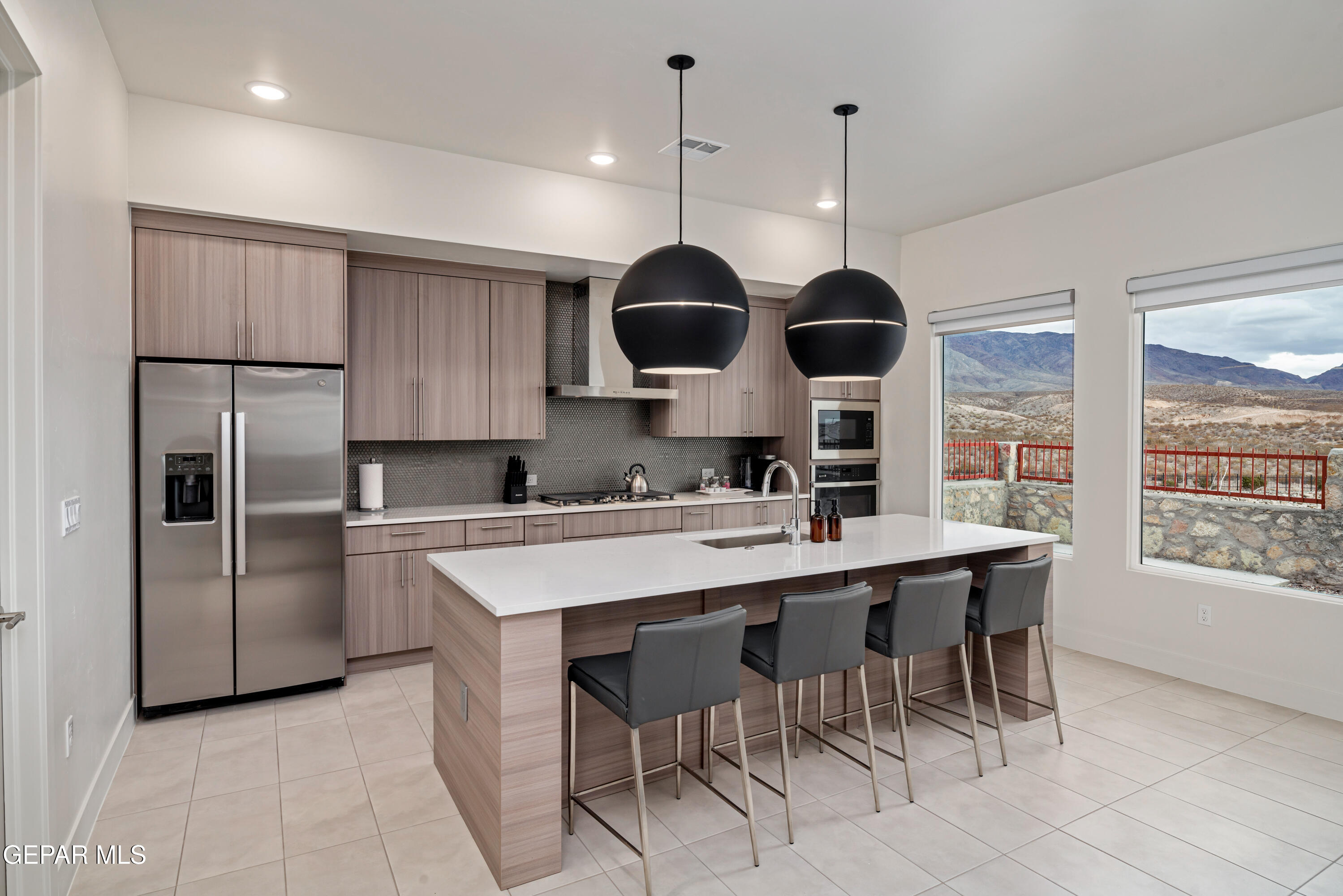 7280 Cimarron Rim Drive El Paso, TX 79911 - Photo 2 of 8 a kitchen with stainless steel appliances granite countertop a sink a stove a refrigerator and island with wooden floor