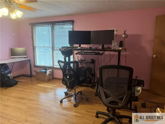 a view of a workspace with furniture and a window