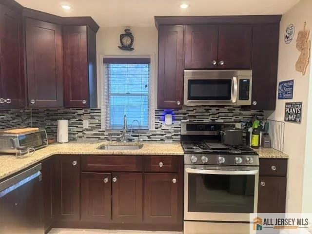 a kitchen with stainless steel appliances a stove a sink and a microwave