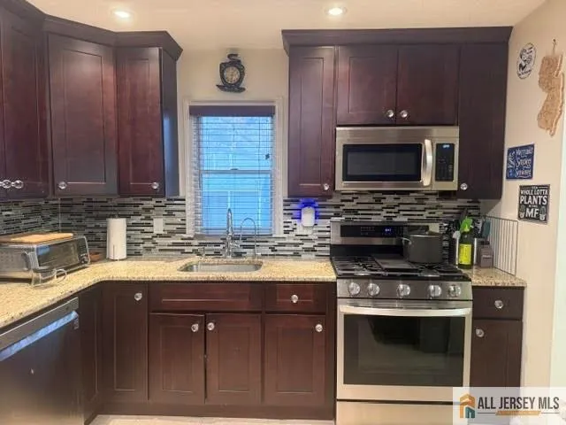 a kitchen with stainless steel appliances a stove a sink and a microwave