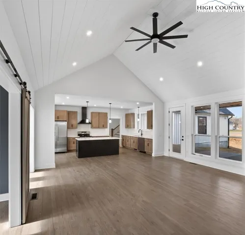 a dining room with wooden floor a chandelier a wooden table and chairs