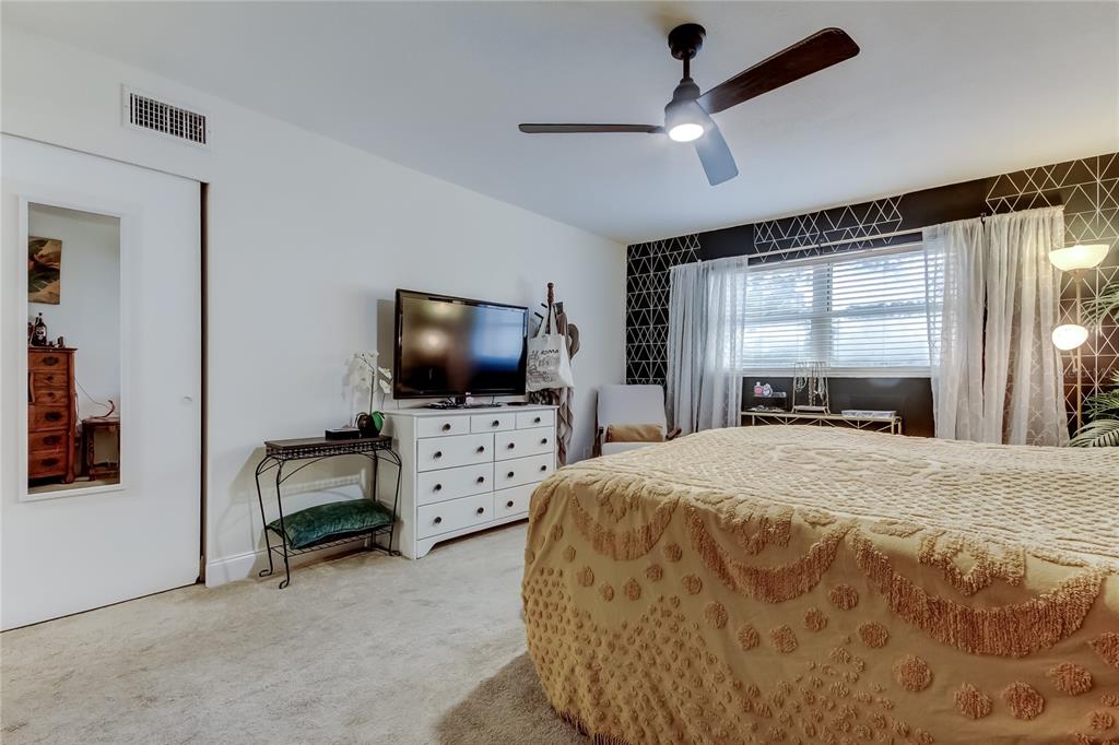 2170 Americus Boulevard North, Unit 64 Clearwater, FL 33763 - Photo 33 of 66 a bedroom with furniture and a flat screen tv