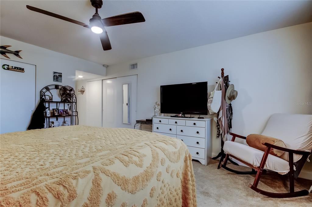 2170 Americus Boulevard North, Unit 64 Clearwater, FL 33763 - Photo 35 of 66 a bedroom with a bed and a flat screen tv