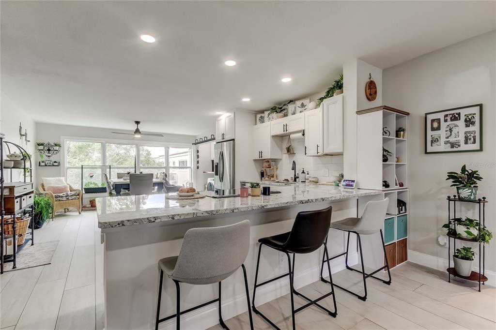 2170 Americus Boulevard North, Unit 64 Clearwater, FL 33763 - Photo 6 of 66 a dining hall with stainless steel appliances kitchen island granite countertop a dining table chairs and white cabinets