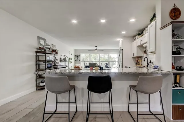 a kitchen view with stainless steel appliances kitchen island granite countertop a sink and cabinets