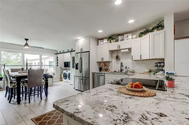a kitchen with a stove cabinets and chairs