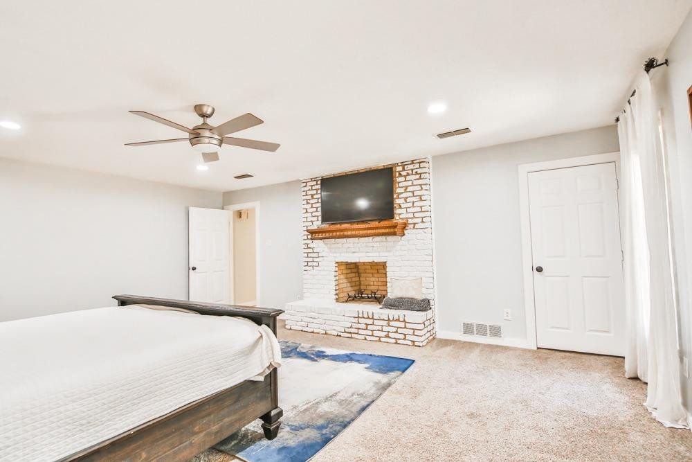 4915 79th Street Lubbock, TX 79424 - Photo 16 of 37 a bedroom with a large bed and a chandelier