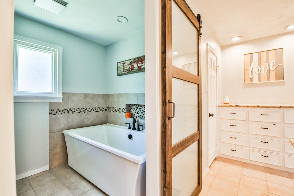 4915 79th Street Lubbock, TX 79424 - Photo 18 of 37 a bathroom with a bathtub and a shower