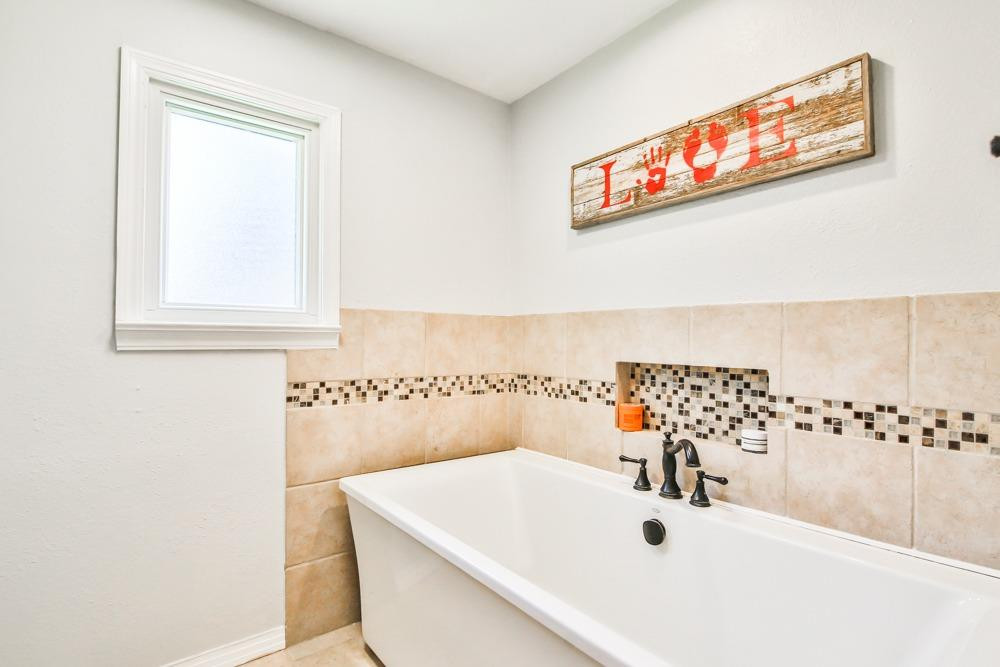 4915 79th Street Lubbock, TX 79424 - Photo 20 of 37 a bathroom with a sink and a bathtub