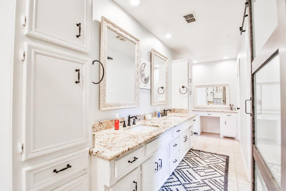 4915 79th Street Lubbock, TX 79424 - Photo 22 of 37 a spacious bathroom with a granite countertop sink mirror and double