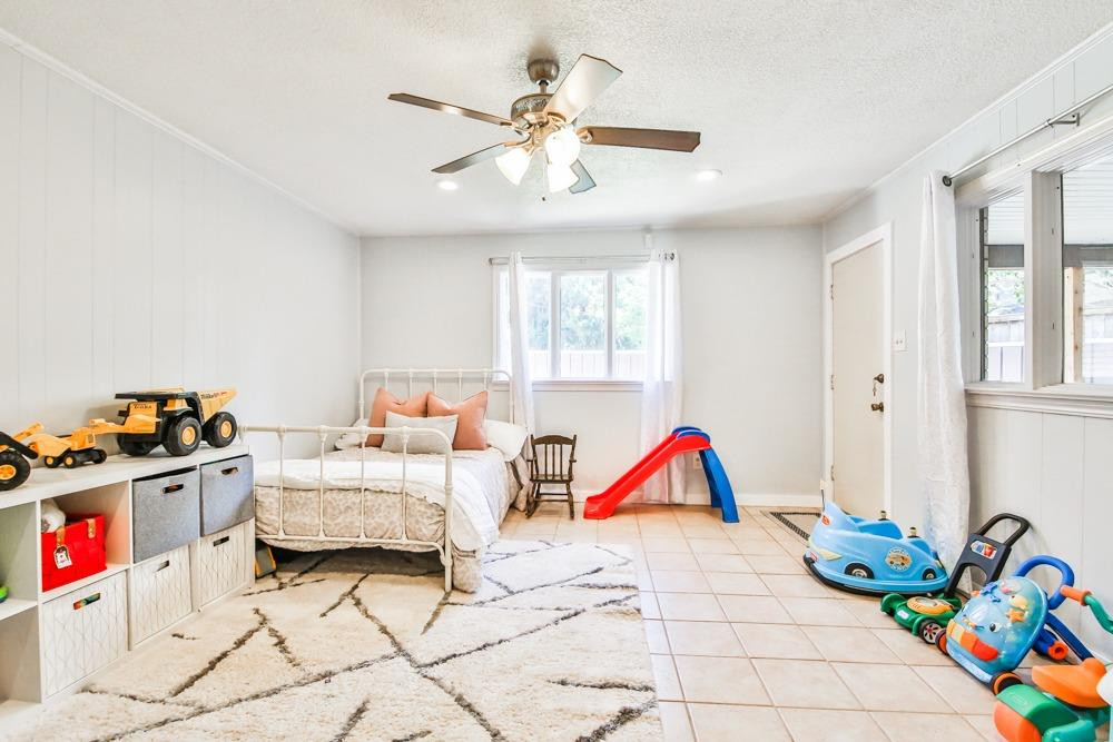 4915 79th Street Lubbock, TX 79424 - Photo 25 of 37 a bedroom with bed and a chandelier