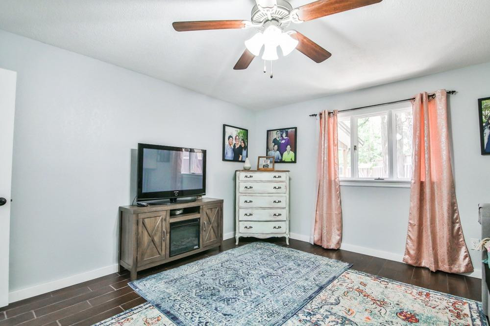 4915 79th Street Lubbock, TX 79424 - Photo 33 of 37 a view of a livingroom with a flat screen tv a ceiling fan and staircase