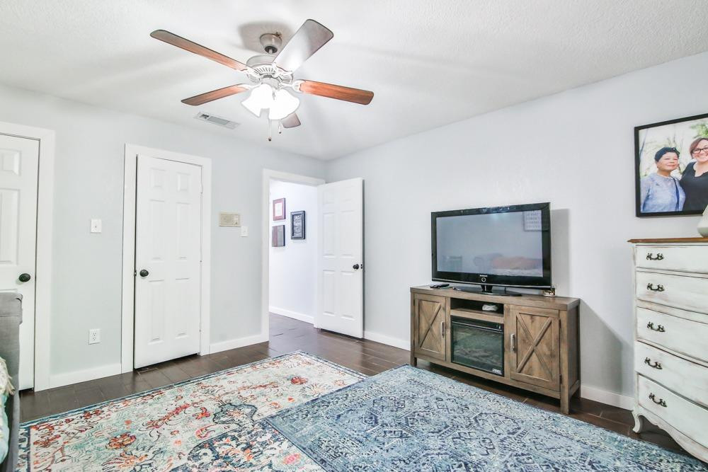 4915 79th Street Lubbock, TX 79424 - Photo 34 of 37 a view of a livingroom with a flat screen tv a ceiling fan and staircase