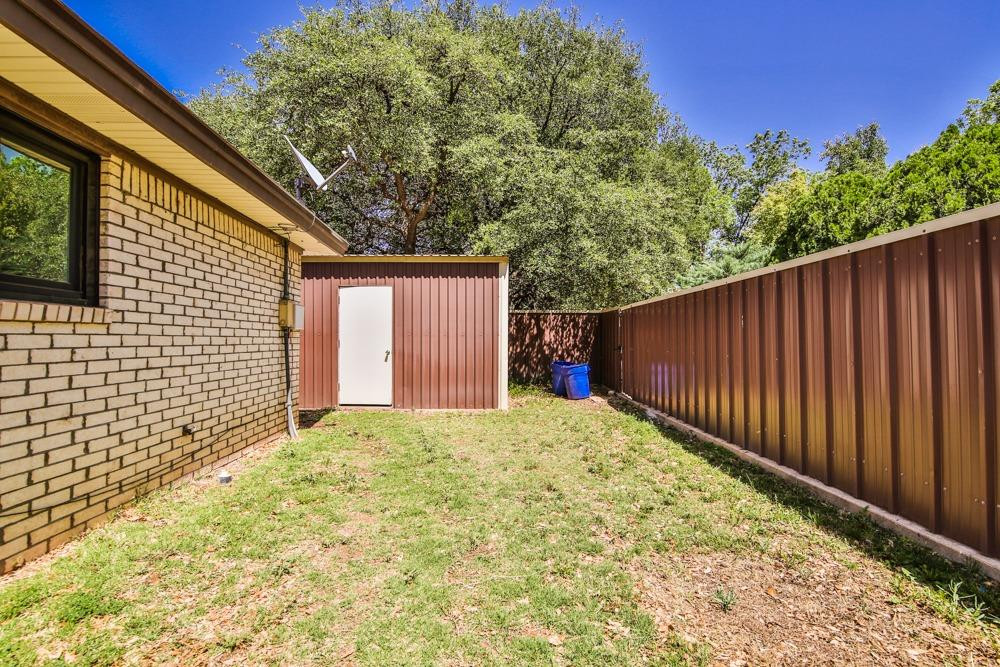 4915 79th Street Lubbock, TX 79424 - Photo 36 of 37 a view of backyard with large trees and wooden fence