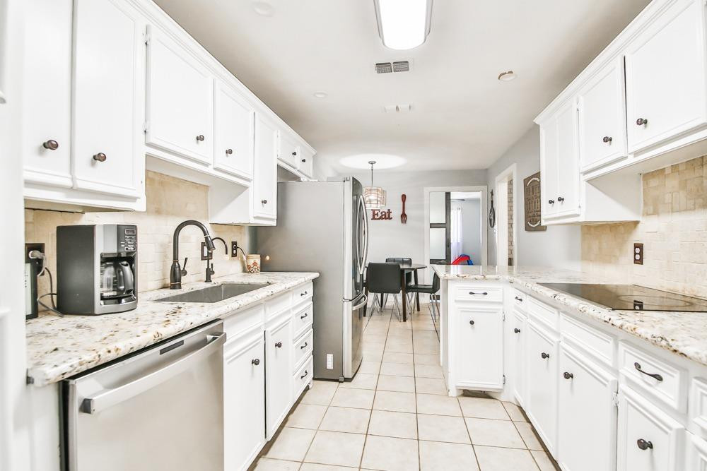 4915 79th Street Lubbock, TX 79424 - Photo 8 of 37 a kitchen with granite countertop a sink stove and cabinets