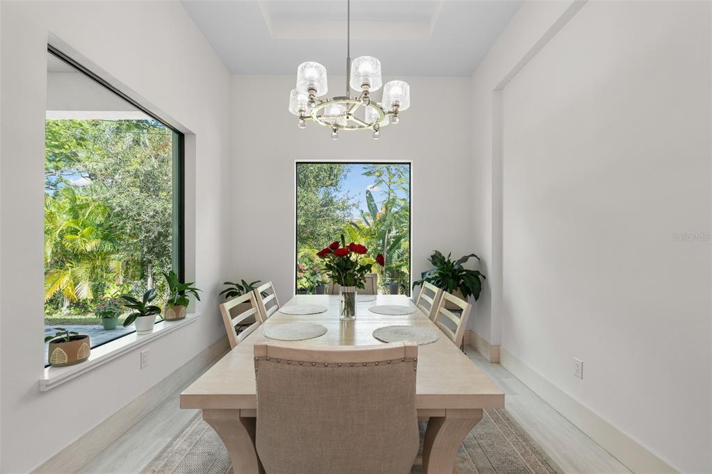 380 Cowry Road Venice, FL 34293 - Photo 19 of 44 a view of a dining room with a large window table and chairs