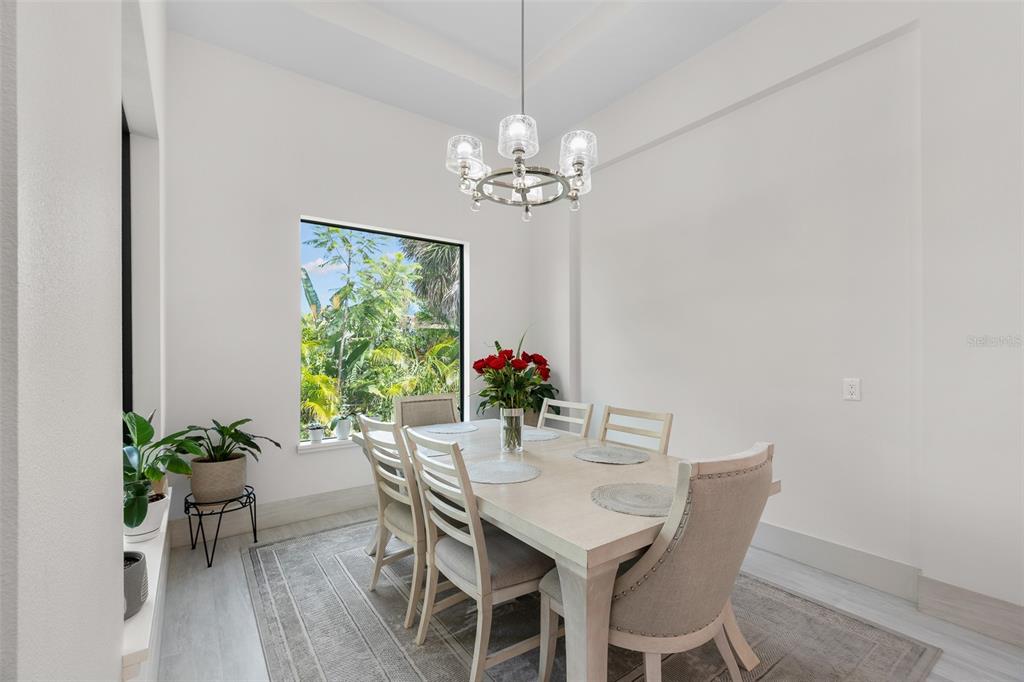 380 Cowry Road Venice, FL 34293 - Photo 20 of 44 a view of a dining room with furniture a chandelier and wooden floor