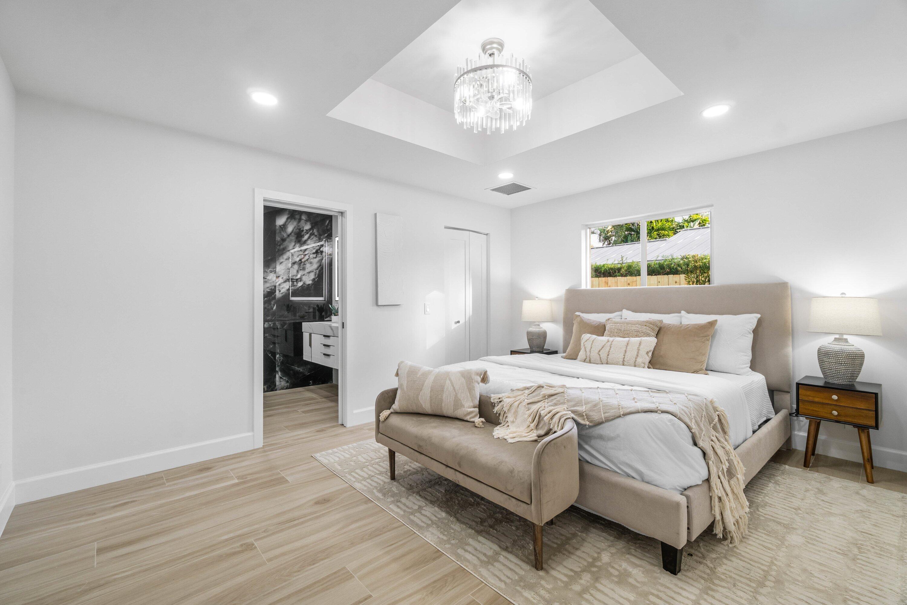 2634 Southwest 5th Street Boynton Beach, FL 33435 - Photo 18 of 57 a spacious bedroom with a bed and a chandelier