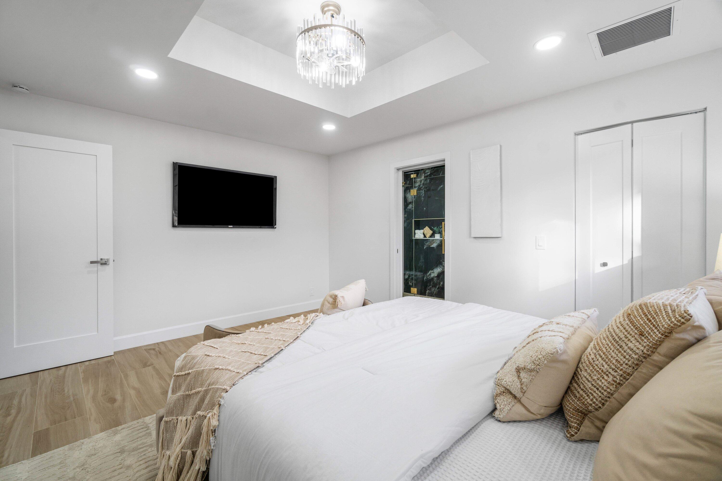 2634 Southwest 5th Street Boynton Beach, FL 33435 - Photo 20 of 57 a bedroom with a large bed and a flat screen tv