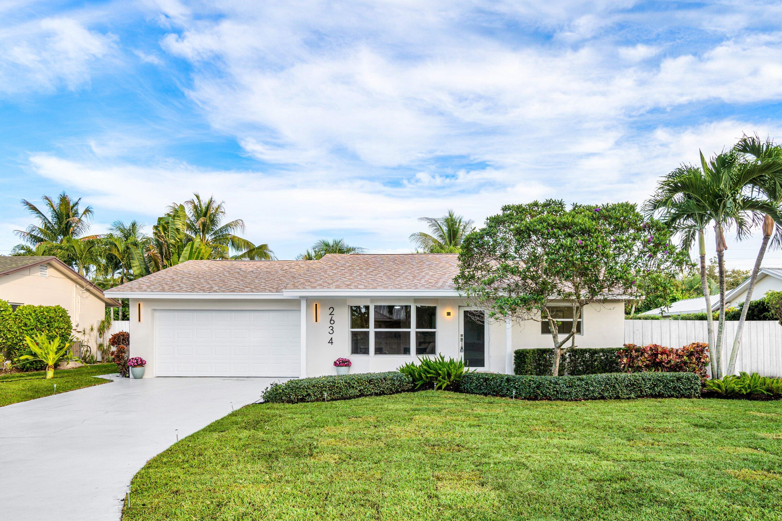 2634 Southwest 5th Street Boynton Beach, FL 33435 - Photo 2 of 57 a front view of a house with a garden and yard