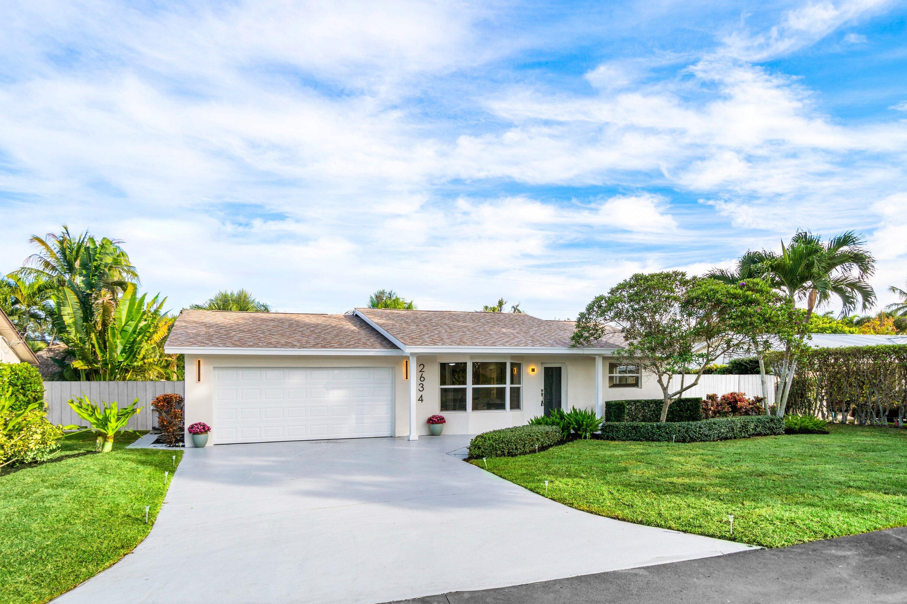 2634 Southwest 5th Street Boynton Beach, FL 33435 - Photo 53 of 57 a front view of a house with a garden and trees