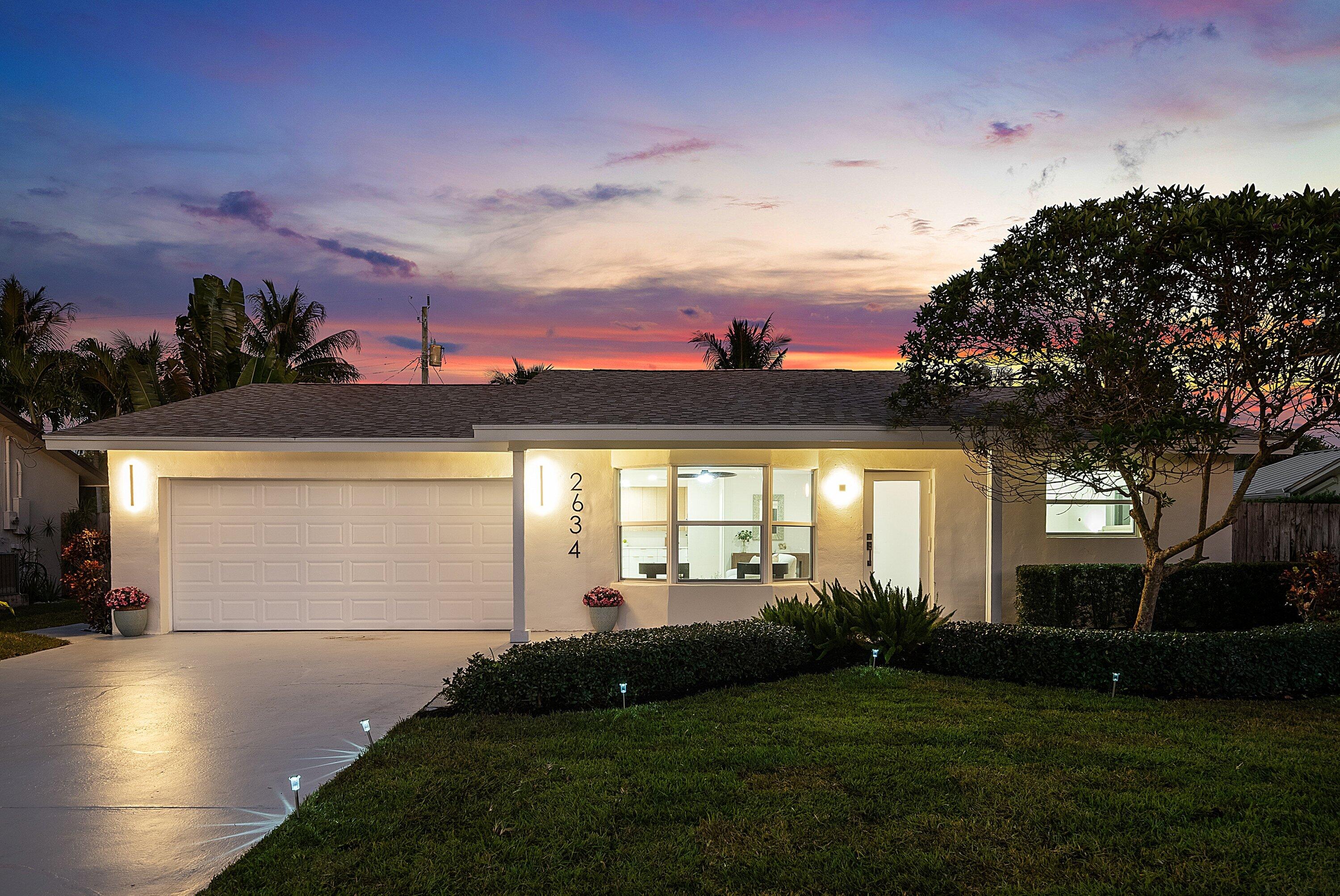 2634 Southwest 5th Street Boynton Beach, FL 33435 - Photo 56 of 57 a view of a white house with a big yard and potted plants