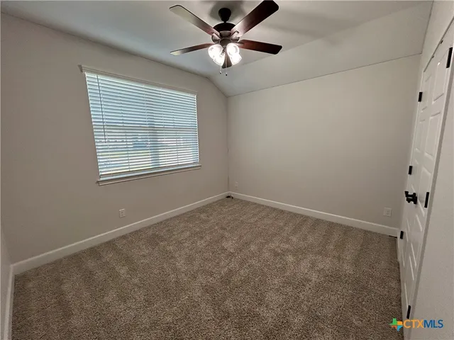 an empty room with a window and a fan