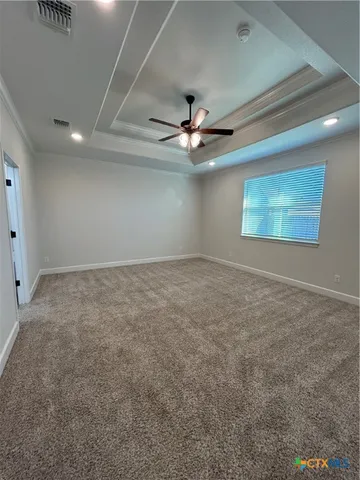 an empty room with windows and fan