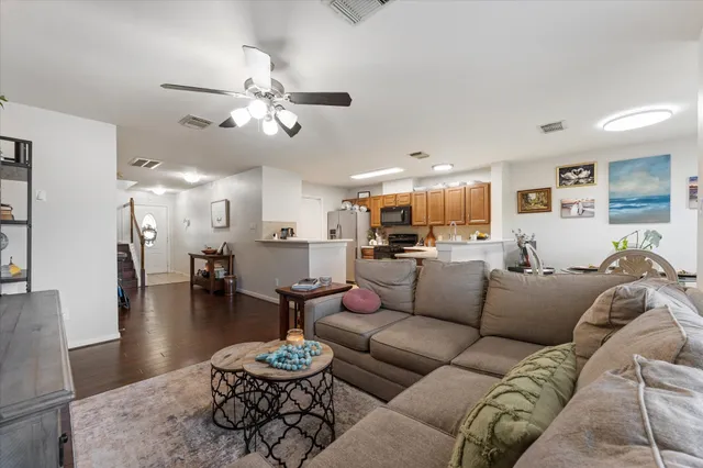 a living room with furniture kitchen view and a chandelier