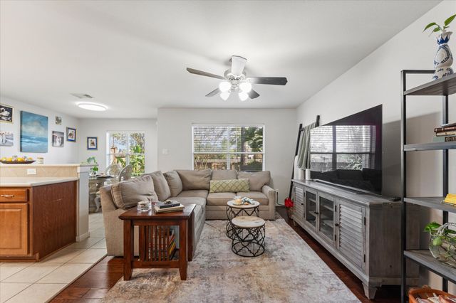 a living room with furniture a flat screen tv and a refrigerator