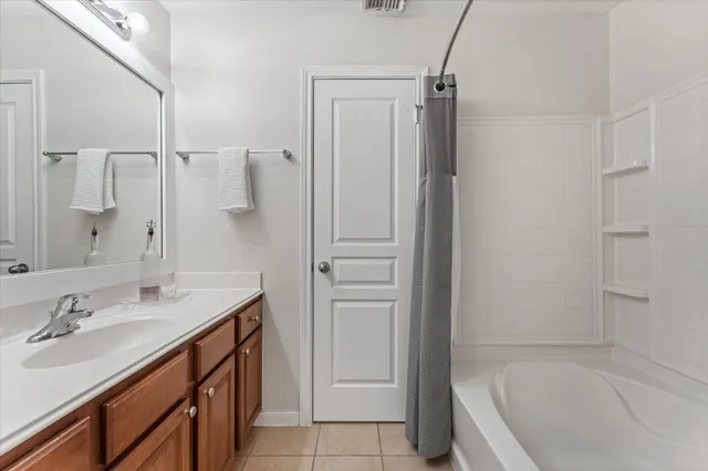a bathroom with a tub sink vanity and mirror