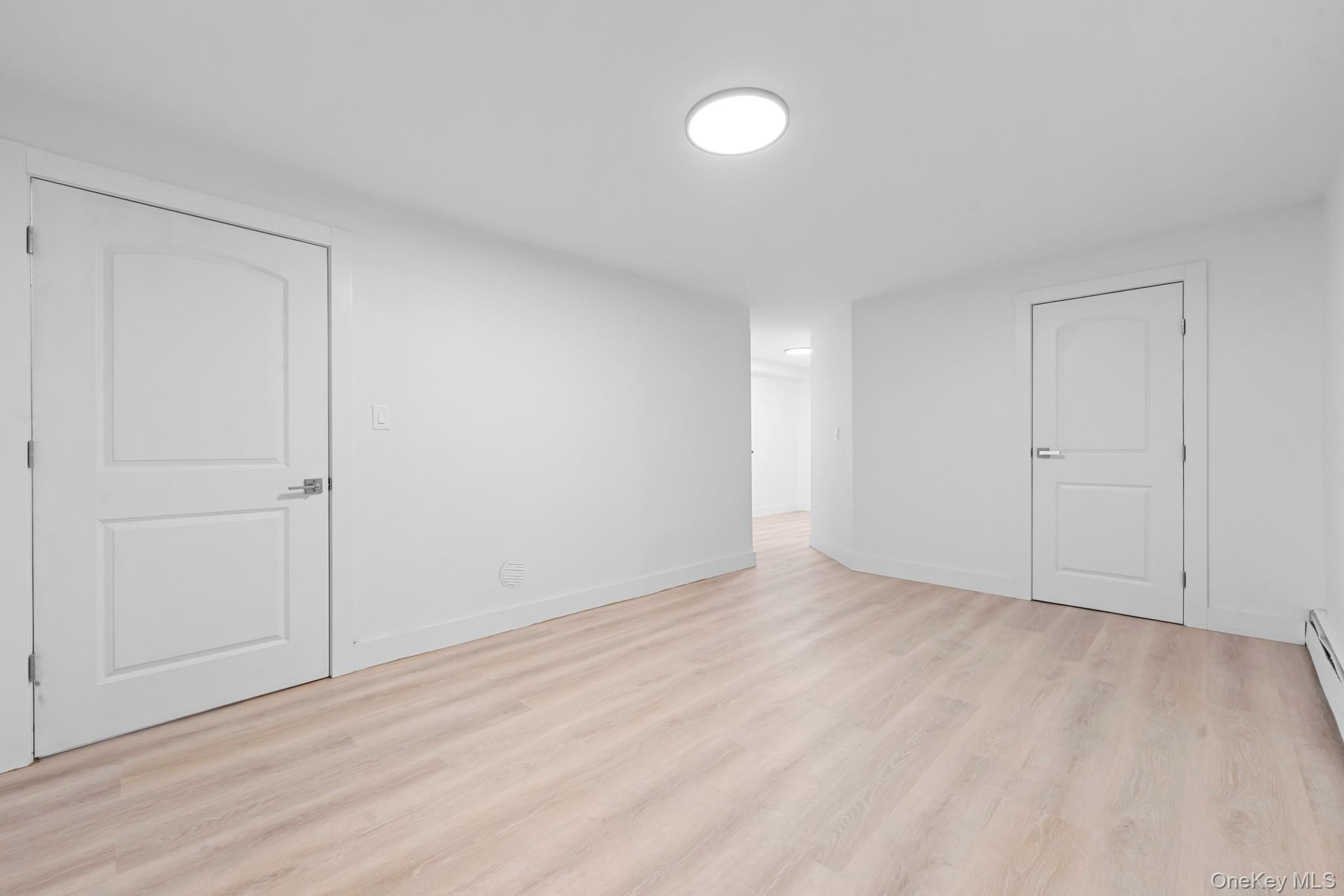 83-32 159th Street Queens, NY 11432 - Photo 12 of 15 a view of an empty room with wooden floor