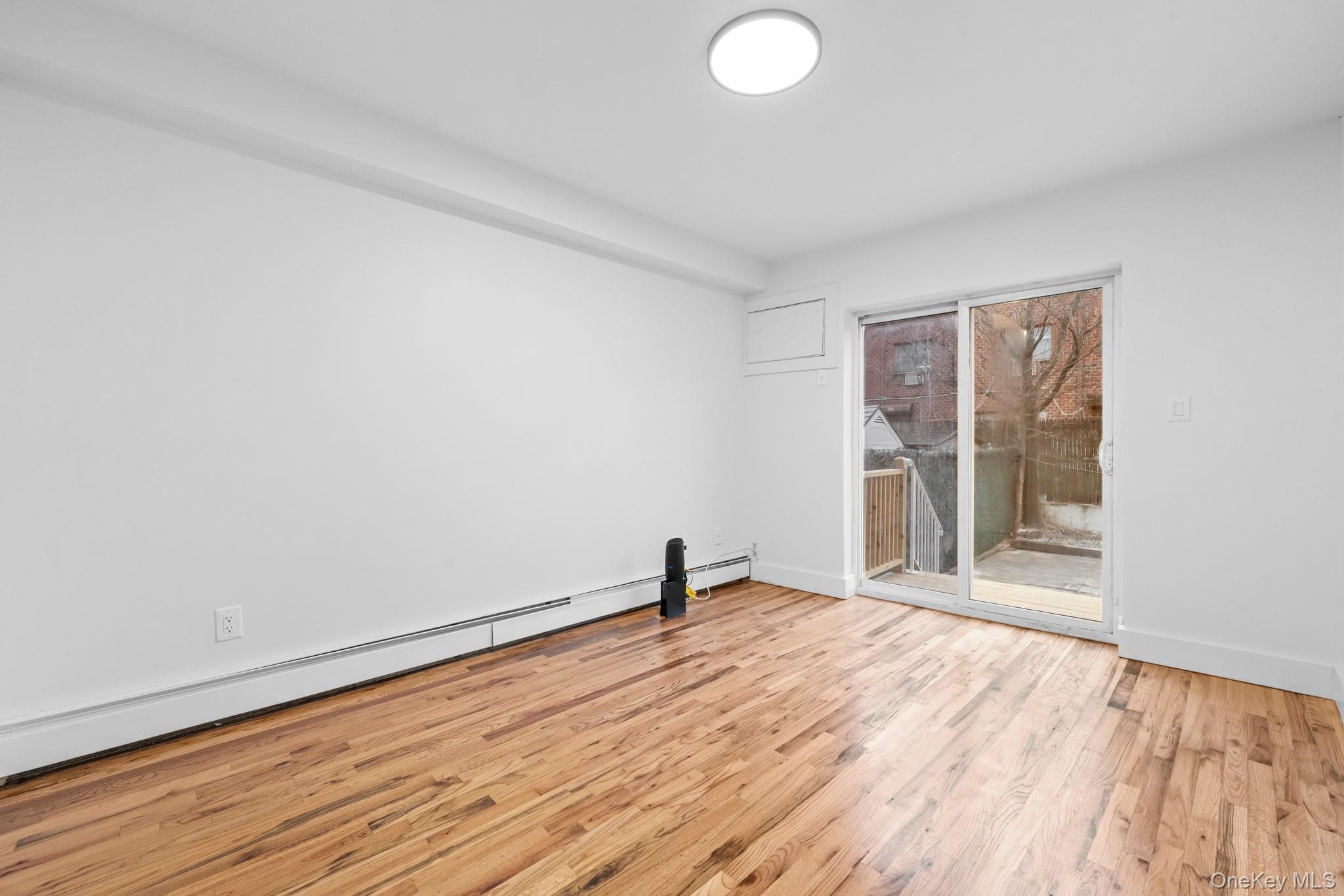 83-32 159th Street Queens, NY 11432 - Photo 5 of 15 a view of empty room with wooden floor and fan