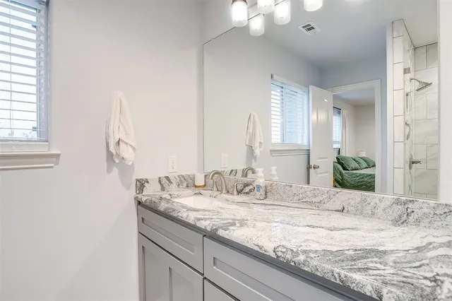 a bathroom with a granite countertop sink and a mirror